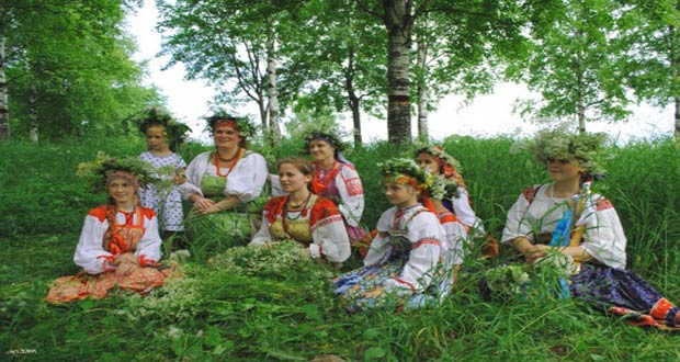 Девушки в народных костюмах плетут венки
